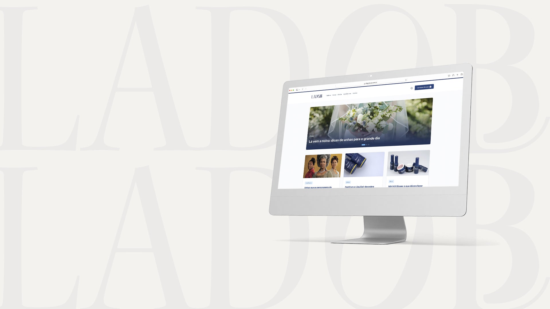 Monitor do modelo iMac com a tela do site inicial do site Lado B, blog da marca Bluwe. No fundo da imagem, fora do monitor, está escrito Lado B duas vezes com opacidade