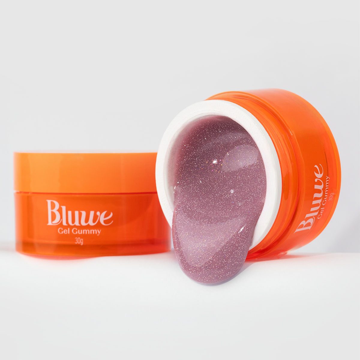 dois potes de gel gummy pink flash, um deles está aberto e tombado, com efeito cascata. gel de cor rosa, com glitter que reflete ao flash