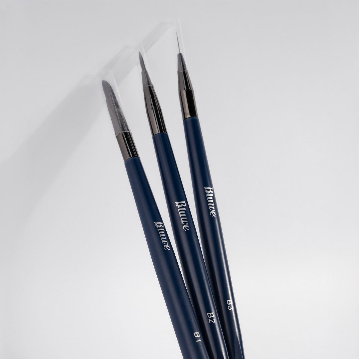 kit de 3 pincéis para aplicação de gel e decoração, os pincéis tem uma tampa transparente e estão alinhados lado a lado em fundo branco