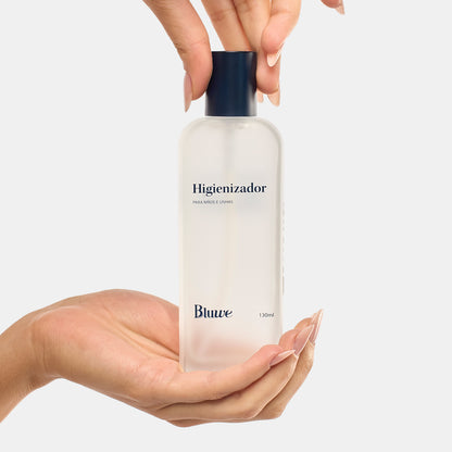 Mãos segurando o novo frasco do Higienizador da Bluwe em fundo branco